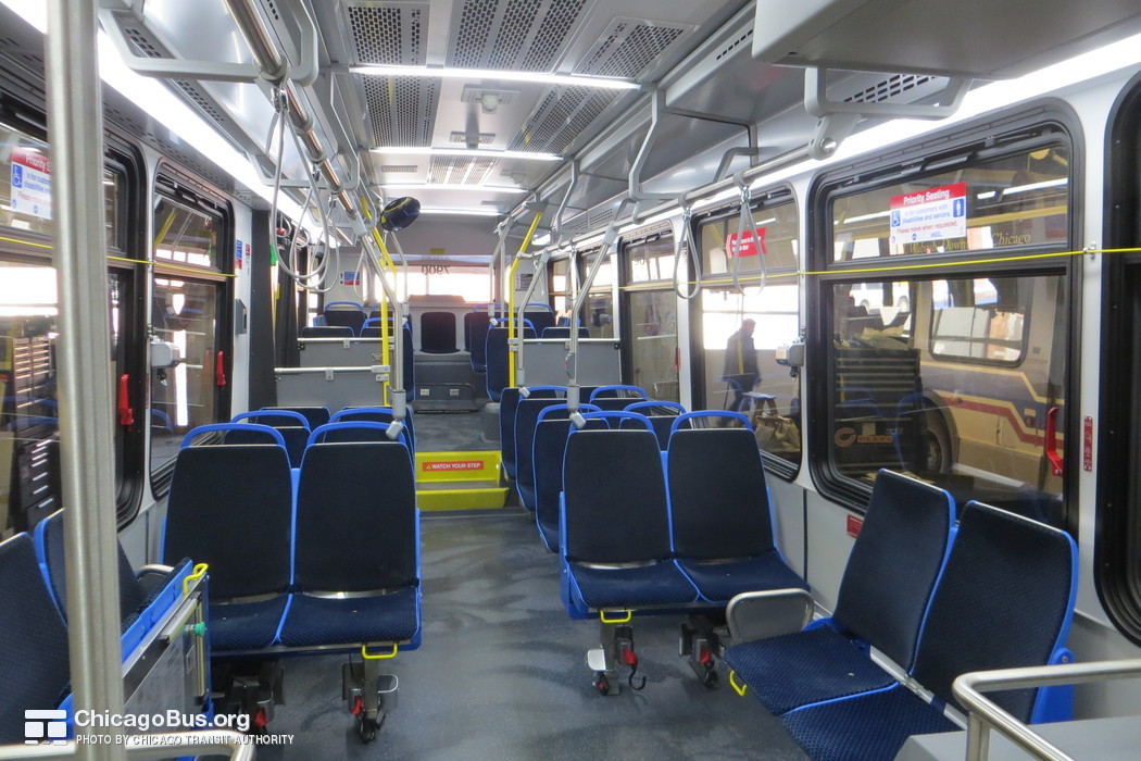 The interior of bus #7900 at CTA's South Shops Maintenance Facility on February  6, 2014. The interior of the 7900-series Novas features several departures from past models. The buses feature new lightweight "Gemini" model seats from Chicago-based Freedman Seating Company. A new slate gray seamless floor design replaces the deep blue grooved flooring that CTA has traditionally used in its bus fleet. Rows of lights now span across the aisle in addition to the traditional rows of lights along the sides of the bus. An improved bulkhead design along the driver's side of the bus provides for increased vertical clearance.