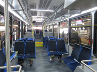 The interior of bus #7900 at CTA's South Shops Maintenance Facility on February  6, 2014. The interior of the 7900-series Novas features several departures from past models. The buses feature new lightweight "Gemini" model seats from Chicago-based Freedman Seating Company. A new slate gray seamless floor design replaces the deep blue grooved flooring that CTA has traditionally used in its bus fleet. Rows of lights now span across the aisle in addition to the traditional rows of lights along the sides of the bus. An improved bulkhead design along the driver's side of the bus provides for increased vertical clearance.